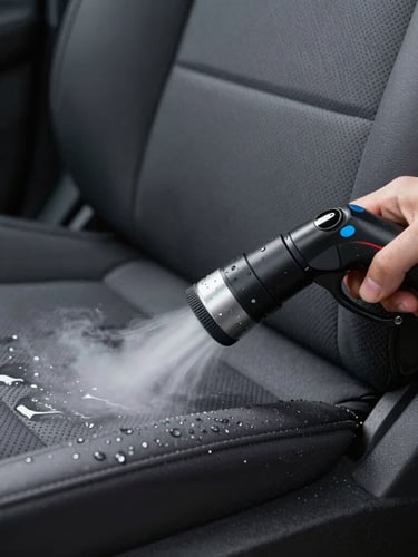 Close-up of a professional steam extraction nozzle deep-cleaning a dark grey car seat fabric, water droplets and clean texture visible under cool LED light.