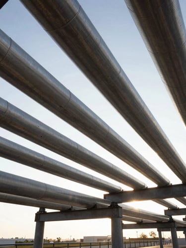 Extreme wide-angle architectural shot of clean, geometric industrial gas pipelines under crisp morning light, high-contrast structural lines, negative space.