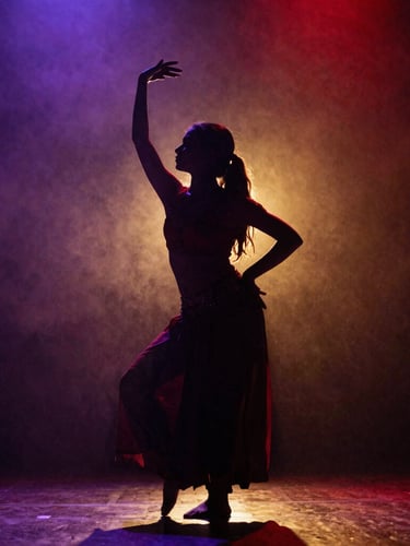 Low-angle high-contrast silhouette of a girl performing ecstatic Dhamal dance, backlit by dramatic deep red and gold light, rich purple haze, raw film grain.
