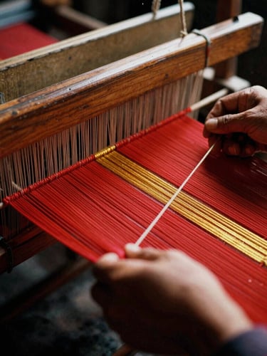 Close-up of hands weaving traditional red and gold thread on a wooden loom, warm dramatic lighting, 35mm film grain