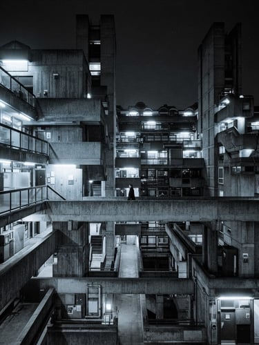 Wide panoramic view of a monolithic concrete brutalist structure under harsh, cold fluorescent lighting, emphasizing scale, sharp technical focus, 35mm.