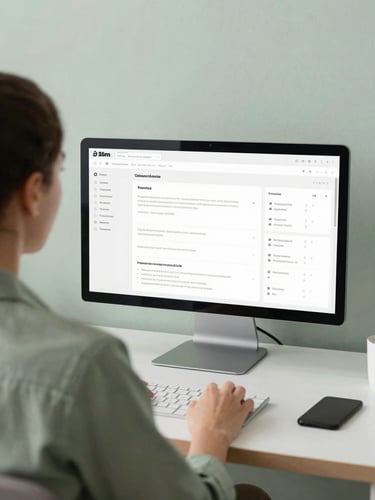 Over-the-shoulder shot of a relaxed business owner looking at a clean, minimalist software interface with soft natural daylight, muted sage tones, 35mm lens.