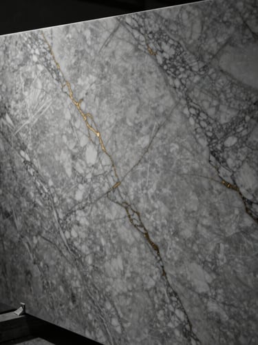 Dramatic close-up of book-matched Calacatta marble slabs in a high-end workshop, moody side-lighting highlighting the golden veins, sharp focus.