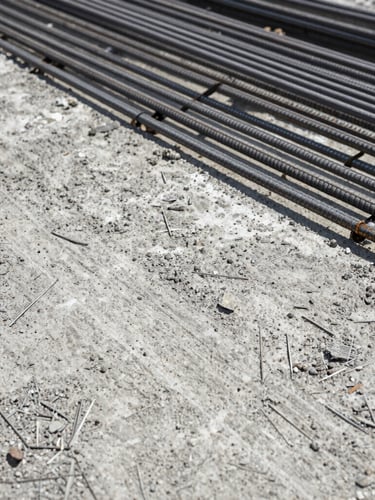 Close-up of raw textured concrete and perfectly aligned steel reinforcement bars, harsh natural daylight, high contrast, gritty documentary style, 35mm
