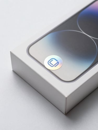 Crisp macro shot of a sealed smartphone box with holographic authenticity seal, high-key studio lighting, neutral minimalist background