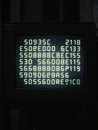 Close-up of a glowing digital terminal screen in a dark Tokyo alley, desaturated, high-contrast, 35mm