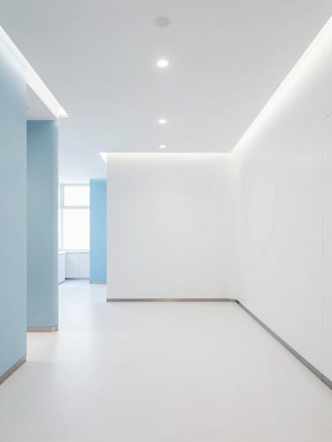 Wide-angle architectural view of a pristine, modern UK dental clinic interior, white walls, soft blue accents, natural daylight, no people, high-end editorial photography, expansive negative space on the left.
