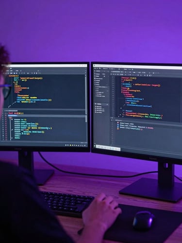 Over-the-shoulder view of a game developer analyzing complex Unity engine code on dual monitors, moody purple backlighting, Austin studio setting, sharp focus, 35mm.