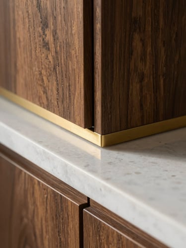 Macro close-up shot of a perfect material junction, dark oak veneer cabinet meeting a polished white quartz countertop with a brass channel detail, soft morning light.