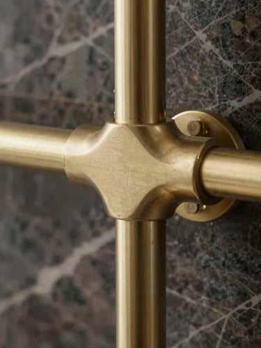 Extreme close-up of champagne-gold bespoke fixtures against dark Italian marble, crisp morning light highlighting the refined textures