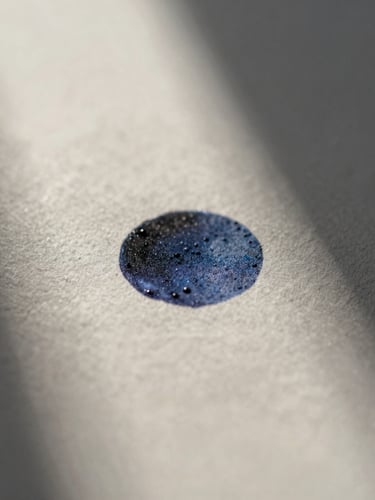 Extreme macro close-up of printed ink on heavy textured paper, soft natural morning light, low-contrast shadows.