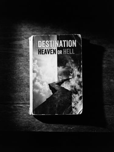 Dramatic high-contrast book mockup of Destination Heaven or Hell, sharp chiaroscuro lighting, deep side-shadows, stark black and white background, 35mm film grain.