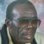 Close-up portrait of an elderly African American man wearing aviator sunglasses.