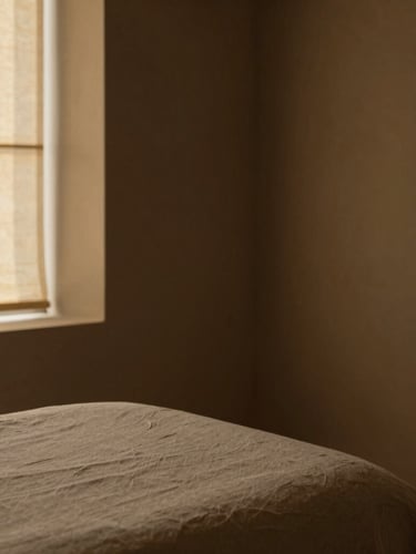Minimalist architectural detail of a quiet room at Aurum Spa, soft linen textures, warm low-key golden-hour light, rich muted earth tones, 35mm