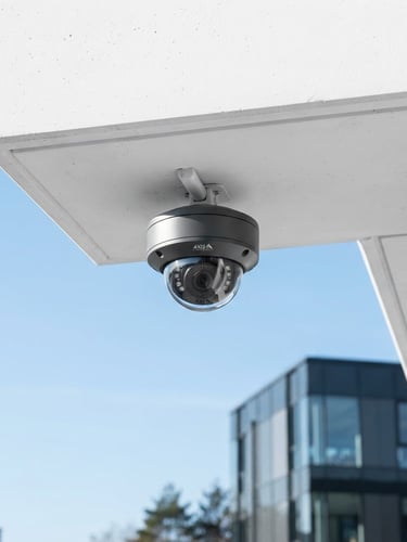 Crisp architectural photography of a sleek, modern dome CCTV camera mounted on a clean white concrete soffit, bright natural daylight, cool blue sky in background, sharp focus, 35mm lens.
