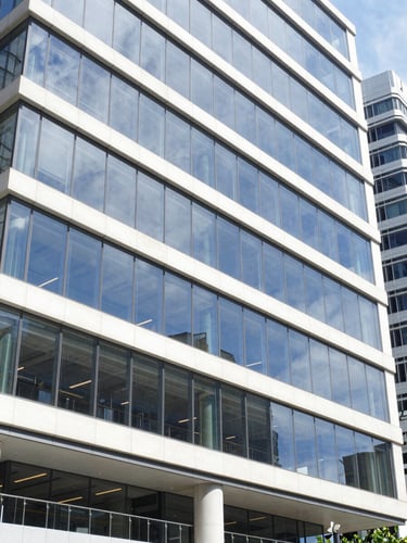 Bright modern commercial building exterior in Sydney, clean glass facade, professional architectural style, daylight