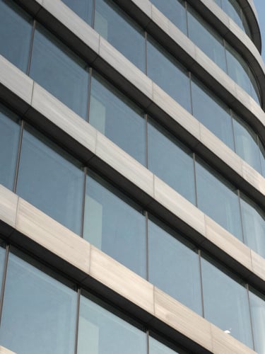 Macro detail of brushed metal and structural glass of a modern corporate headquarters in Riyadh, sharp crisp daylight.