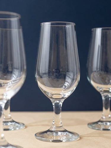 Sharp close-up of premium tempered glassware catching bright natural daylight, highlighting clarity and official manufacturer stamps, deep navy background, 50mm lens