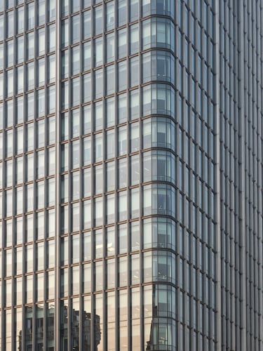 Architectural elevation of a modern steel and glass skyscraper in Noida, crisp daylight, sharp geometric lines, premium architectural photography