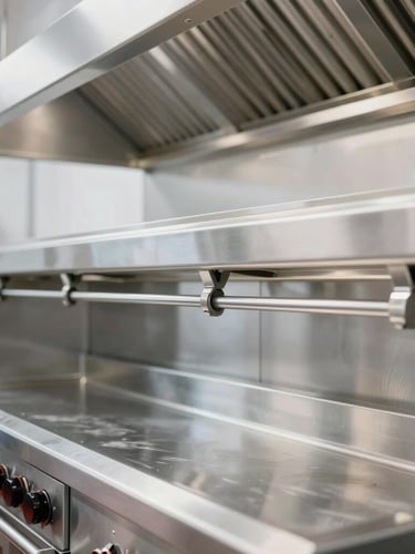 Close-up of a pristine, professional stainless steel commercial kitchen hot line, bright industrial lighting, sharp reflection on exhaust hood.