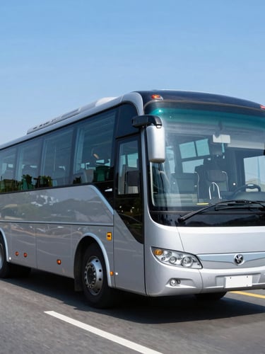 Dynamic low-angle tracking shot of a modern clean executive bus on a highway during bright daylight, pristine silver and navy paint, 35mm photography
