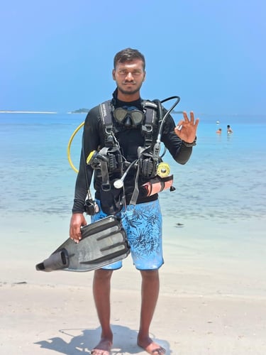 a man in a wetsuit and scuba gear standing on a beach