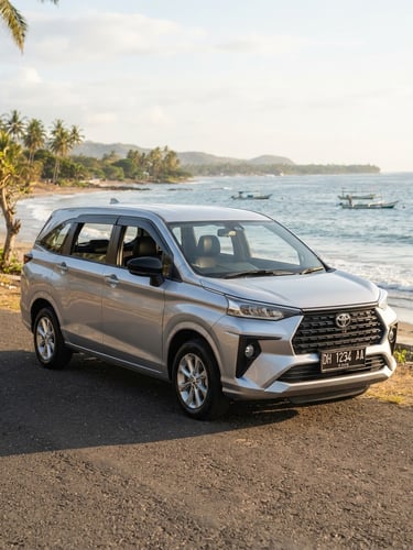 Eye-level three-quarter shot of a clean silver Toyota Avanza parked near Lasiana Beach under warm morning sunlight, professional automotive photography, 35mm lens