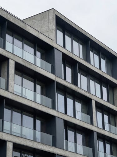 A sharp architectural crop of a modern concrete and steel building facade, cool overcast daylight, navy and slate gray tones, sharp focus, 35mm