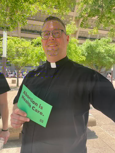 a preacher holding a sign that says, abortion is health care