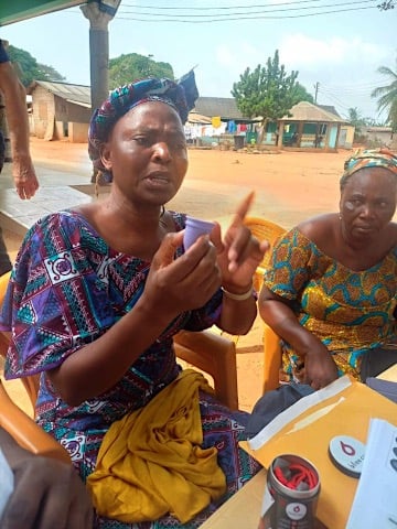 Mama Adzorhlor III, Queen Mother of Dagbamete, addressing the women while holding a menstrual cup.