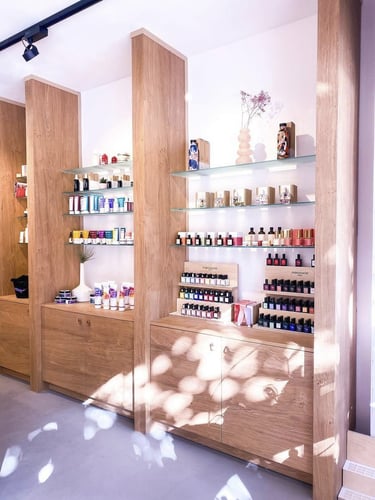 Réalisation de l'aménagement de Cozybee avec les étagères en bois devant un mur rose doux et épuré