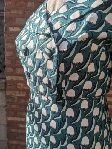 The front of a green art nouveau reversible sheath dress and 50's inspired cropped jacket