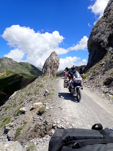 a person riding a motorcycle down a mountain side