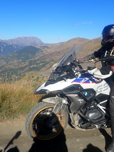 a man in a black jacket and helmet on a motorcycle