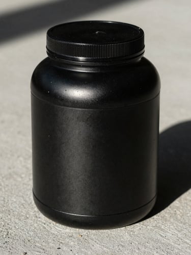 High-contrast close-up of a black matte supplement tub on a raw concrete surface, sharp side lighting, dramatic shadows, athletic grit