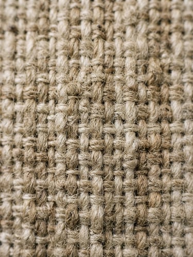Extreme macro close-up of unbleached oatmeal linen fabric weave, soft natural daylight, tactile fiber detail, 35mm film look