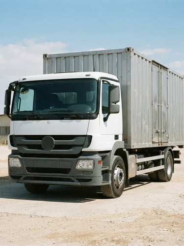 Straight-on documentary photo of a humanitarian delivery truck in bright natural daylight, silver logistics containers, sharp focus, 35mm