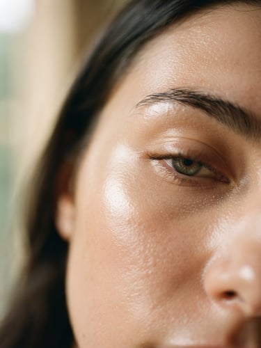 Macro shot of healthy, glowing skin with soft morning light reflecting off the cheekbone, clean minimalist composition, shallow depth of field, 35mm