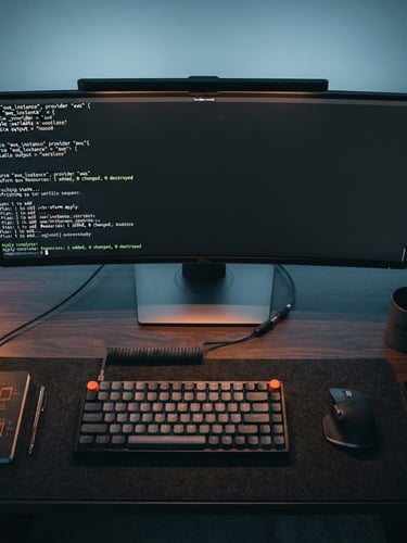 Overhead view of an engineer's clean desk setup, terminal screen displaying active Terraform scripts, subtle orange glow, cool desaturated blue ambient lighting, sharp focus, 35mm.