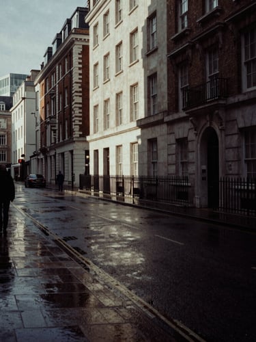 Moody editorial photography of a wet London streetscape in the City of London, low-key lighting, deep charcoal tones, dramatic shadows, 35mm film grain