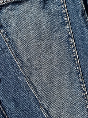 Tactile film photography of raw 14oz Japanese selvedge denim texture, harsh daylight, high contrast, showing deep indigo weave and red selvedge ID line