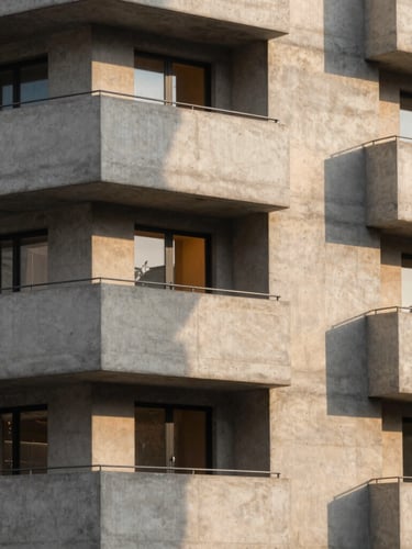 Architectural portrait of a modern concrete residential facade, sharp geometric shadows, warm amber light glowing from a single window