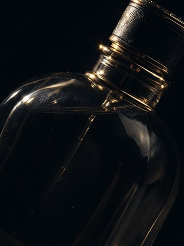 Extreme macro shot of a heavy dark glass perfume bottle catching sharp gold glints of light, low-key chiaroscuro lighting, deep black background, 85mm lens.