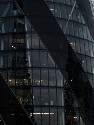 Macro architectural detail of the Shard in London, sharp steel and glass angles casting harsh geometric shadows under cool-toned low-key lighting, high contrast, 35mm lens