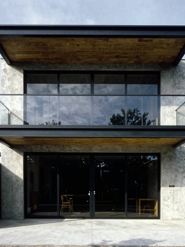 Straight-on architectural elevation of a modern steel and concrete extension, sharp shadows, high-contrast daylight, 35mm