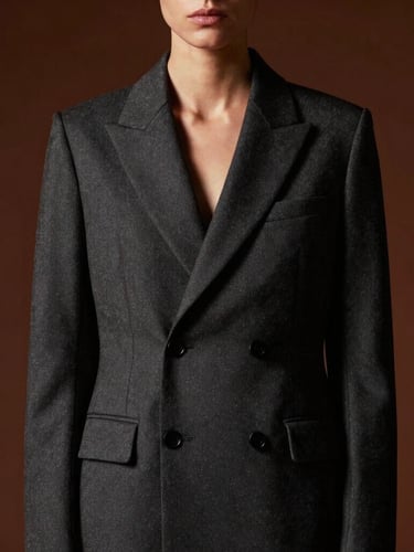 Editorial fashion shot of a model in a sharp, structured obsidian-toned ready-to-wear garment, dramatic directional studio key light, rich warm undertones, sharp focus
