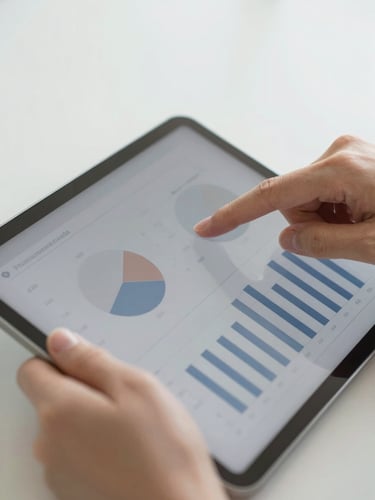 Close-up of hands analyzing clean charts on a tablet, soft natural daylight, muted navy and warm gray tones, clean composition, shallow depth of field