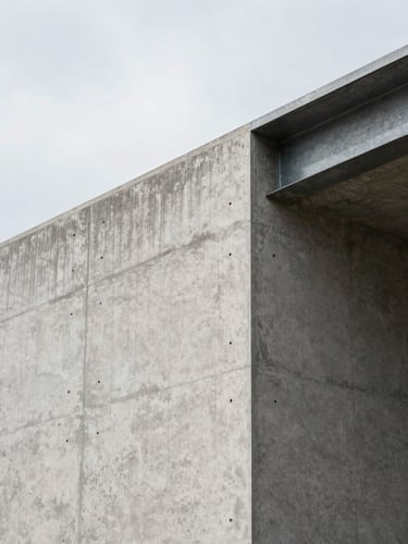 Close-up panoramic of a raw concrete wall junction meeting an exposed steel beam at a building corner, north-facing diffused daylight raking across the surface revealing formwork texture and aggregate, no workers, no people, wide environmental framing with generous negative space to the upper left