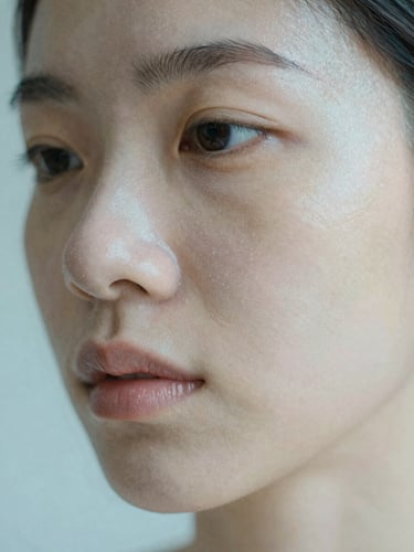 Macro portrait of healthy, hydrated skin texture showing natural pores, soft diffused morning light with a subtle cool blue glow, shallow depth of field.