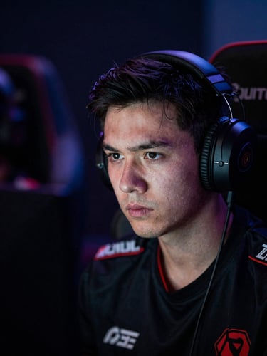 Close-up of a competitive gamer's intense expression, face illuminated by screen glow, low-light environment, sharp details, cinematic depth of field.